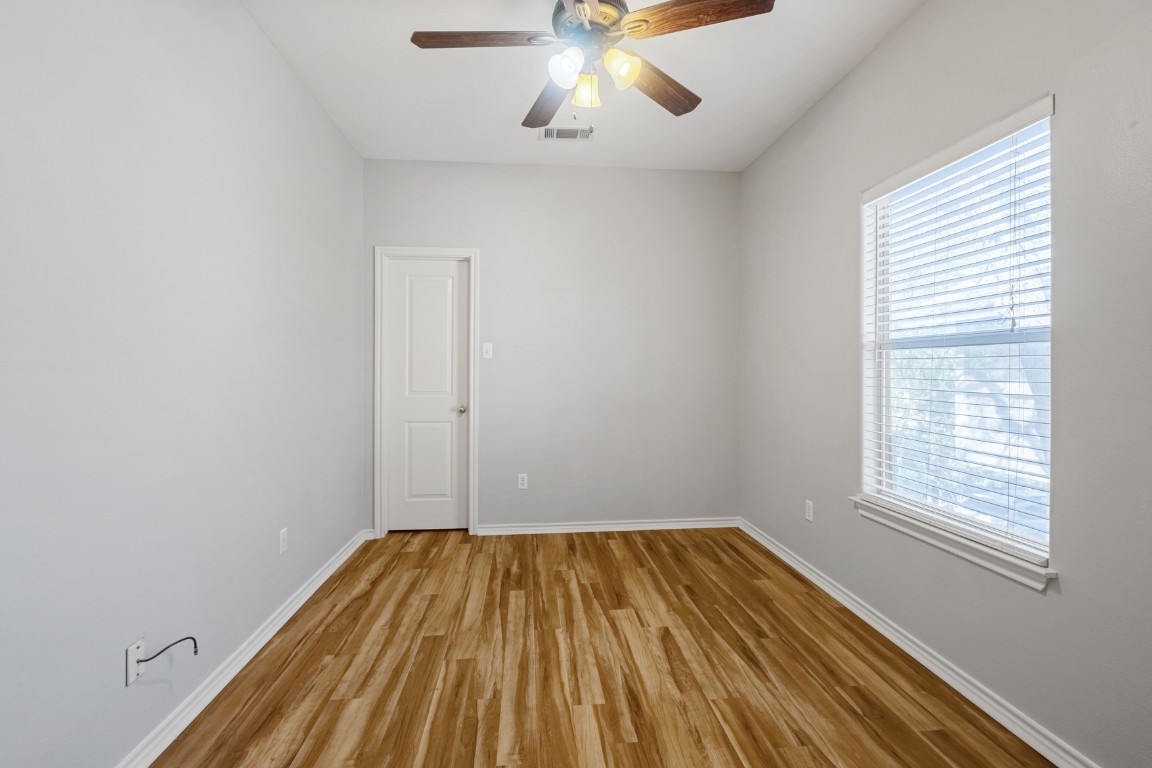 2906 Pearl Street, Unit C Austin, TX 78705 - Photo 17 of 25 Unfurnished room with wood finished floors and ceiling fan