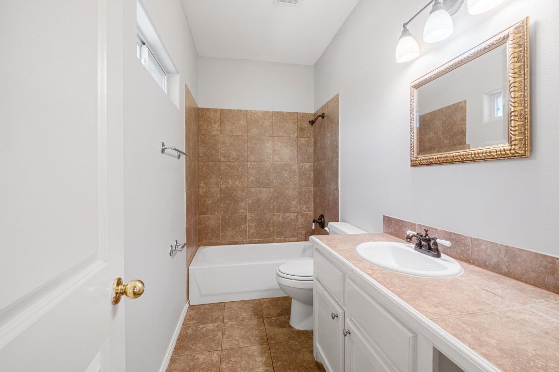 2906 Pearl Street, Unit C Austin, TX 78705 - Photo 21 of 25 Bathroom with vanity, shower / washtub combination, and dark tile patterned floors
