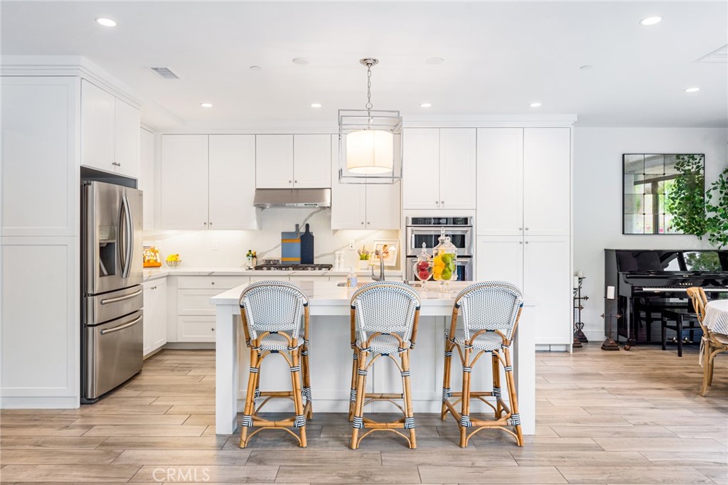 218 Oceano Irvine, CA 92602 - Photo 30 of 56 a kitchen with stainless steel appliances granite countertop a dining table chairs refrigerator and sink