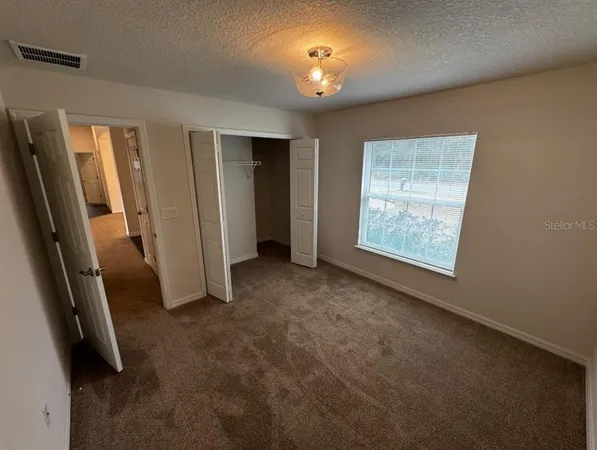 an empty room with windows and closet