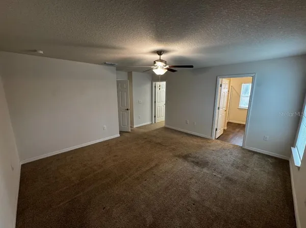 en empty room with windows and fan