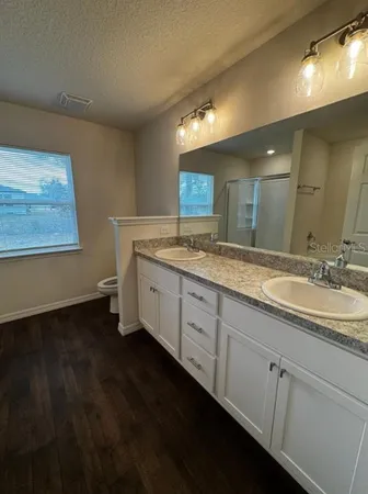 a spacious bathroom with a double vanity sink and a mirror