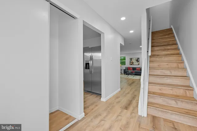 a view of a hallway with wooden floor and staircase