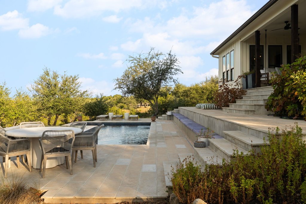 32045 Mirela Ann Road Dripping Springs, TX 78620 - Photo 28 of 30 Multi-level stone terraces descend to a private swimming pool set against scenic hills.