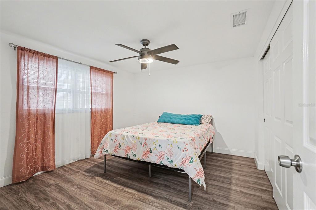 11828 Bingham Drive Port Richey, FL 34668 - Photo 16 of 32 a bedroom with a bed and wooden floor