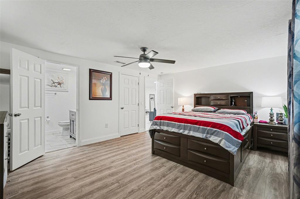 11828 Bingham Drive Port Richey, FL 34668 - Photo 18 of 32 a bedroom with a bed and a ceiling fan