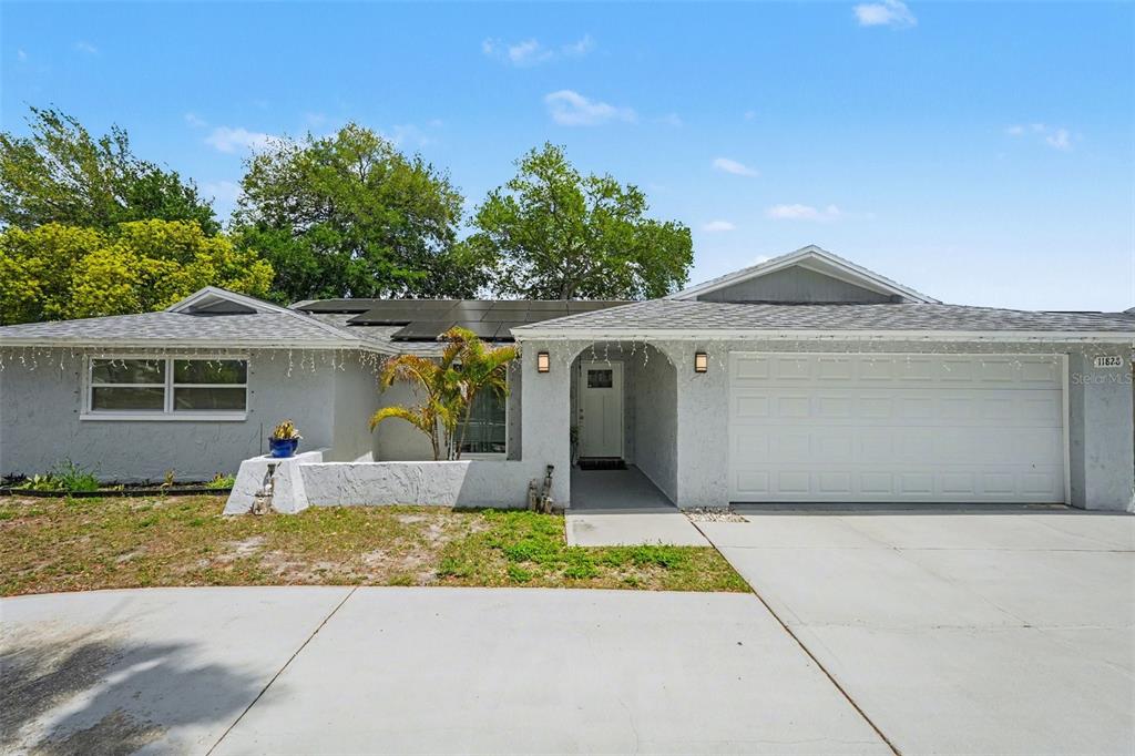 11828 Bingham Drive Port Richey, FL 34668 - Photo 2 of 32 a front view of a house with a yard and garage