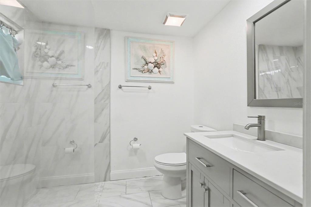 11828 Bingham Drive Port Richey, FL 34668 - Photo 21 of 32 a bathroom with a toilet sink and mirror
