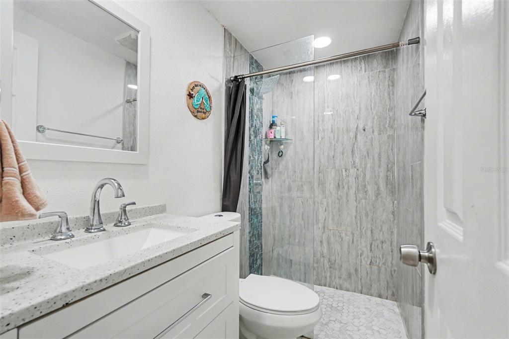 11828 Bingham Drive Port Richey, FL 34668 - Photo 22 of 32 a bathroom with a sink a toilet and shower