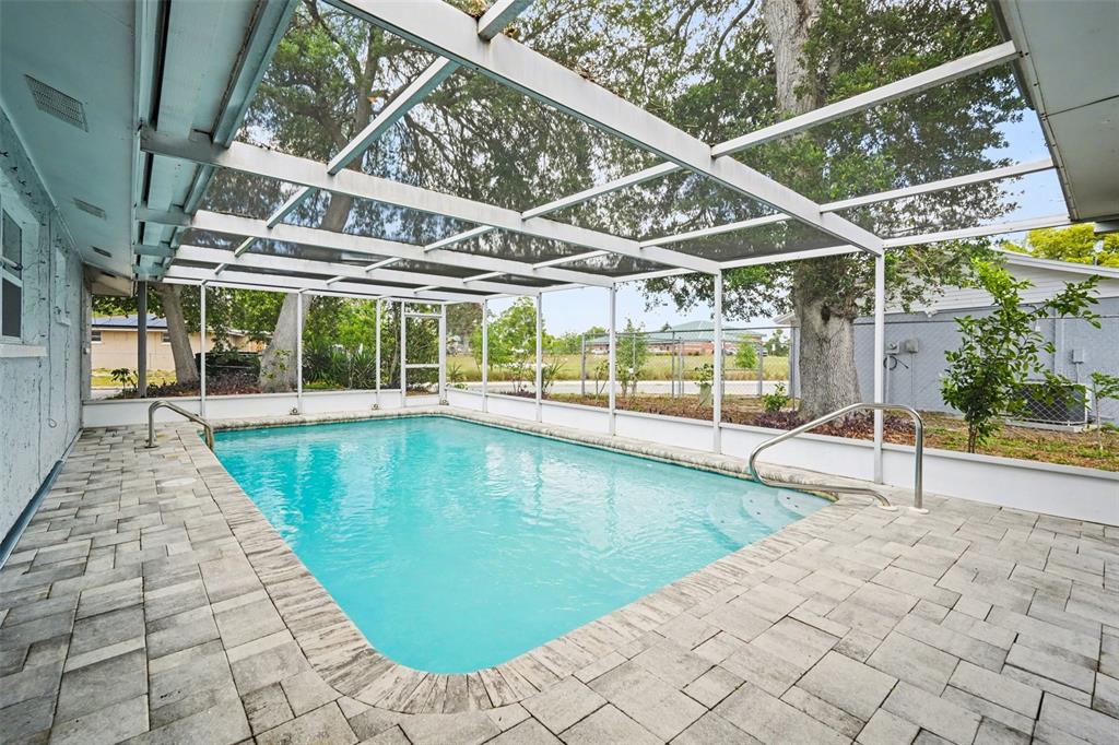 11828 Bingham Drive Port Richey, FL 34668 - Photo 26 of 32 a view of a swimming pool with a porch