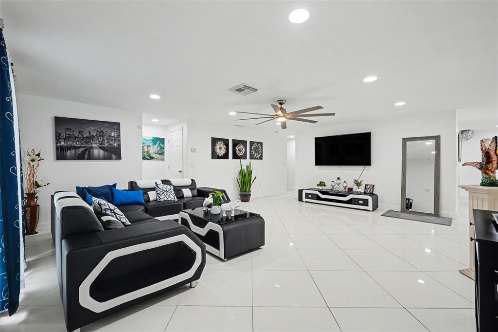 11828 Bingham Drive Port Richey, FL 34668 - Photo 8 of 32 a living room with furniture and a flat screen tv