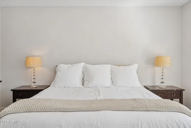 a bedroom with a bed and lamps