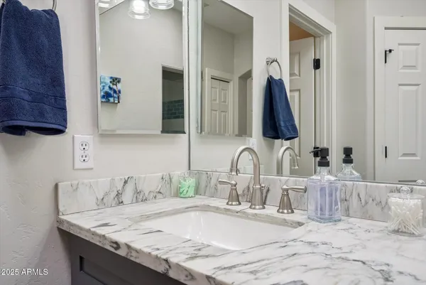 a bathroom with a granite countertop sink and a mirror