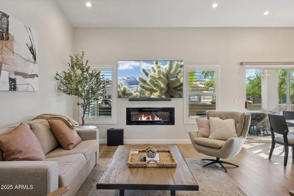 a living room with furniture a fireplace and a large window