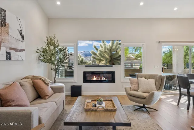 a living room with furniture a fireplace and a large window