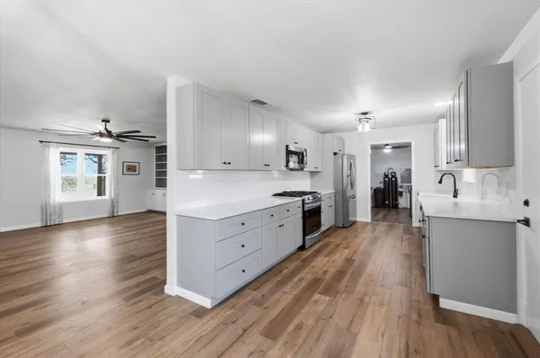 a large kitchen with a lot of counter space and wooden floor