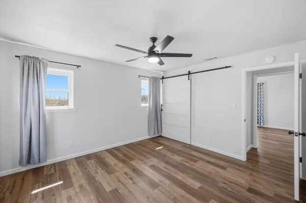 a view of a livingroom with a ceiling fan wooden floor and window