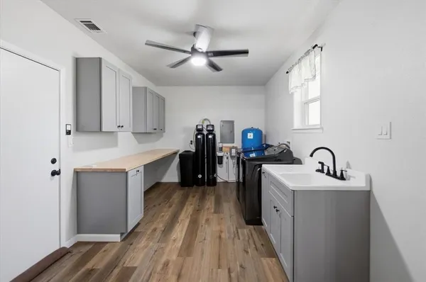 a large white kitchen with sink a refrigerator and cabinets