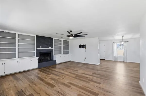 an empty room with windows and fireplace