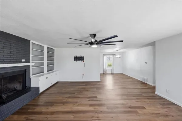 a view of an empty room with a fireplace and a window