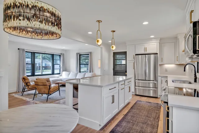 a kitchen that has a lot of cabinets in it and stainless steel appliances