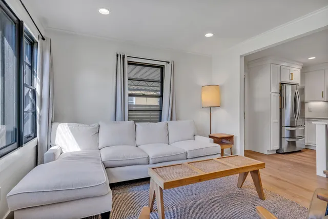 a living room with furniture a lamp and a window