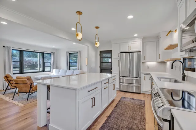 a kitchen with stainless steel appliances granite countertop a sink stove and refrigerator