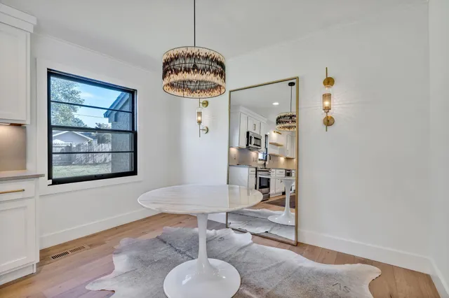 a view of a livingroom and dining room with furniture wooden floor and a chandelier