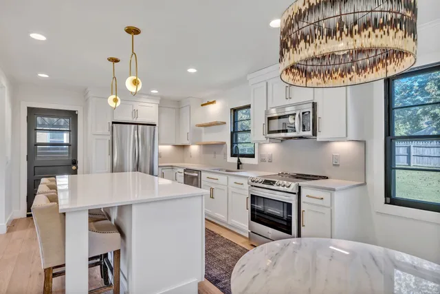a kitchen with a stove a refrigerator and a table