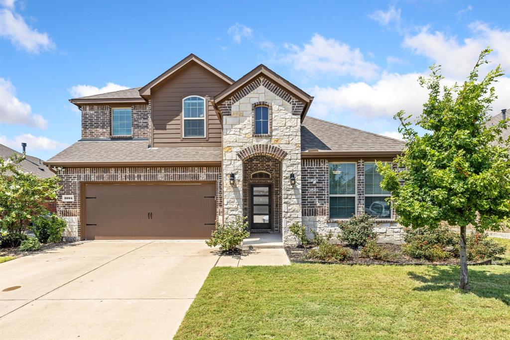 French provincial home featuring a garage, a shingled roof, stone siding, driveway, and a front lawn