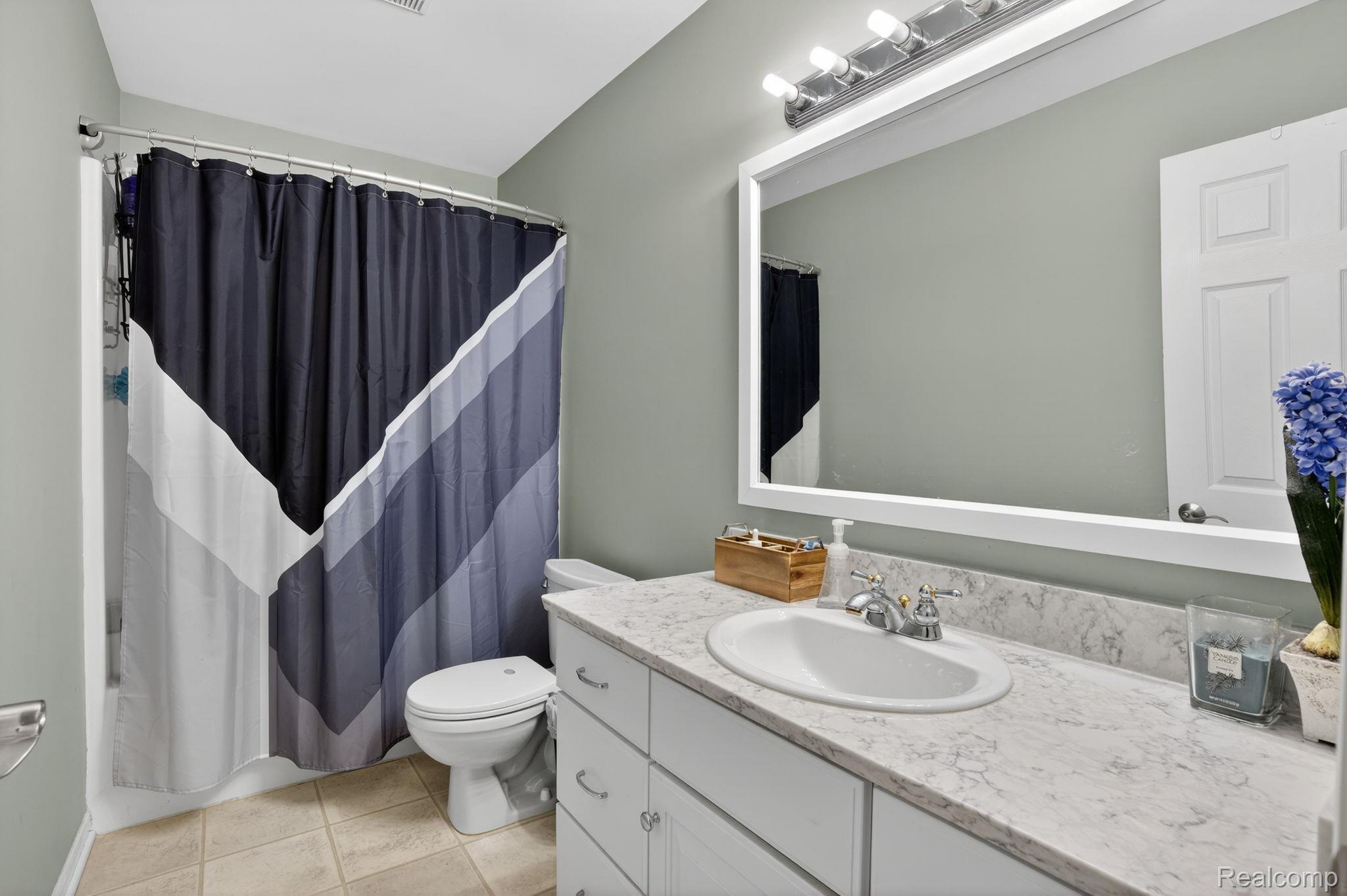 9055 Hegel Road Grand Blanc, MI 48439 - Photo 38 of 62 Vanity with a white oval sink, chrome faucet, and a light-toned countertop