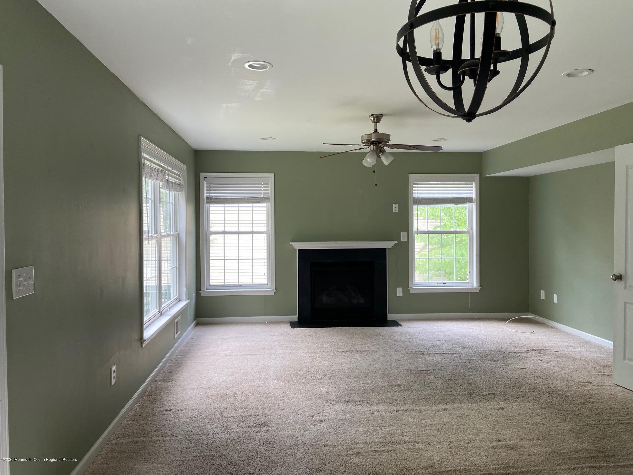 213 Topside Road Manahawkin, NJ 08050 - Photo 6 of 16 a view of an empty room with a fireplace and a window