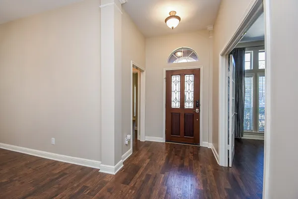 a view of a hallway with wooden floor and a living room