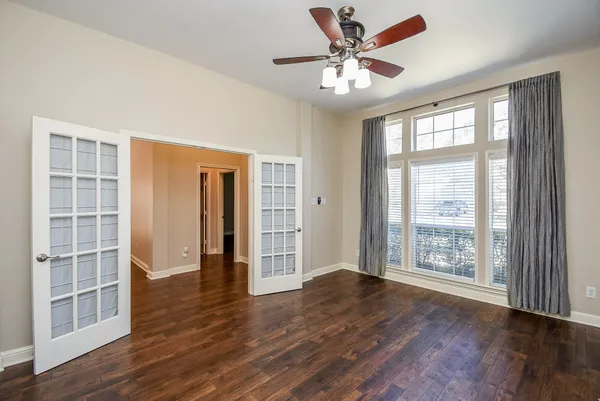 a view of an empty room with wooden floor and a window