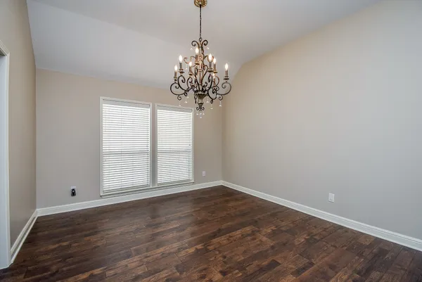 a view of a big room with wooden floor and windows in it