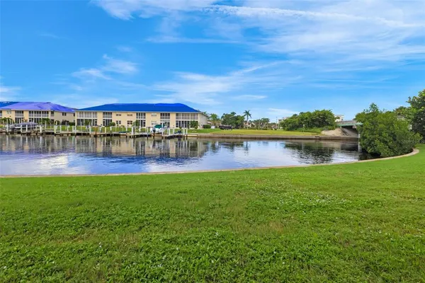 a view of a lake with a yard and large trees