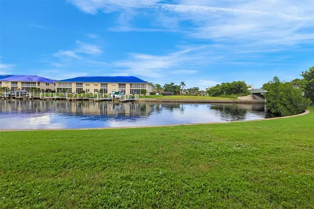 a view of a lake with a yard and large trees