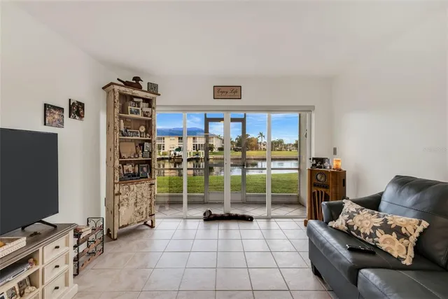 a living room with furniture a flat screen tv and a window