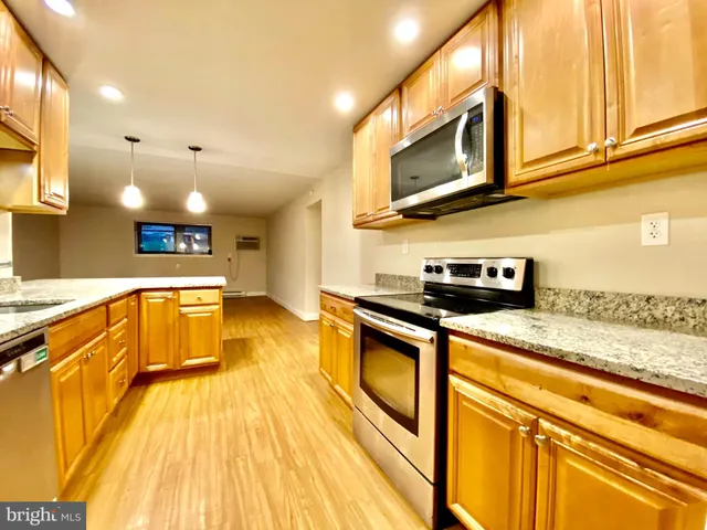 a kitchen with stainless steel appliances granite countertop a sink and a stove
