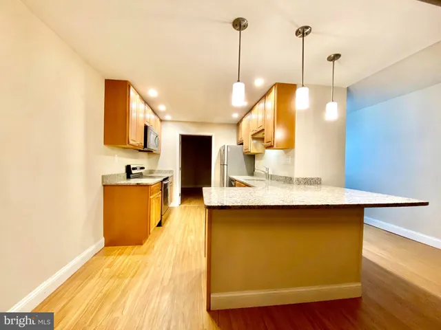 a kitchen with kitchen island a sink appliances and wooden floor