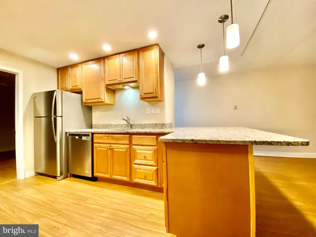 a kitchen with stainless steel appliances a sink a stove a refrigerator and cabinets