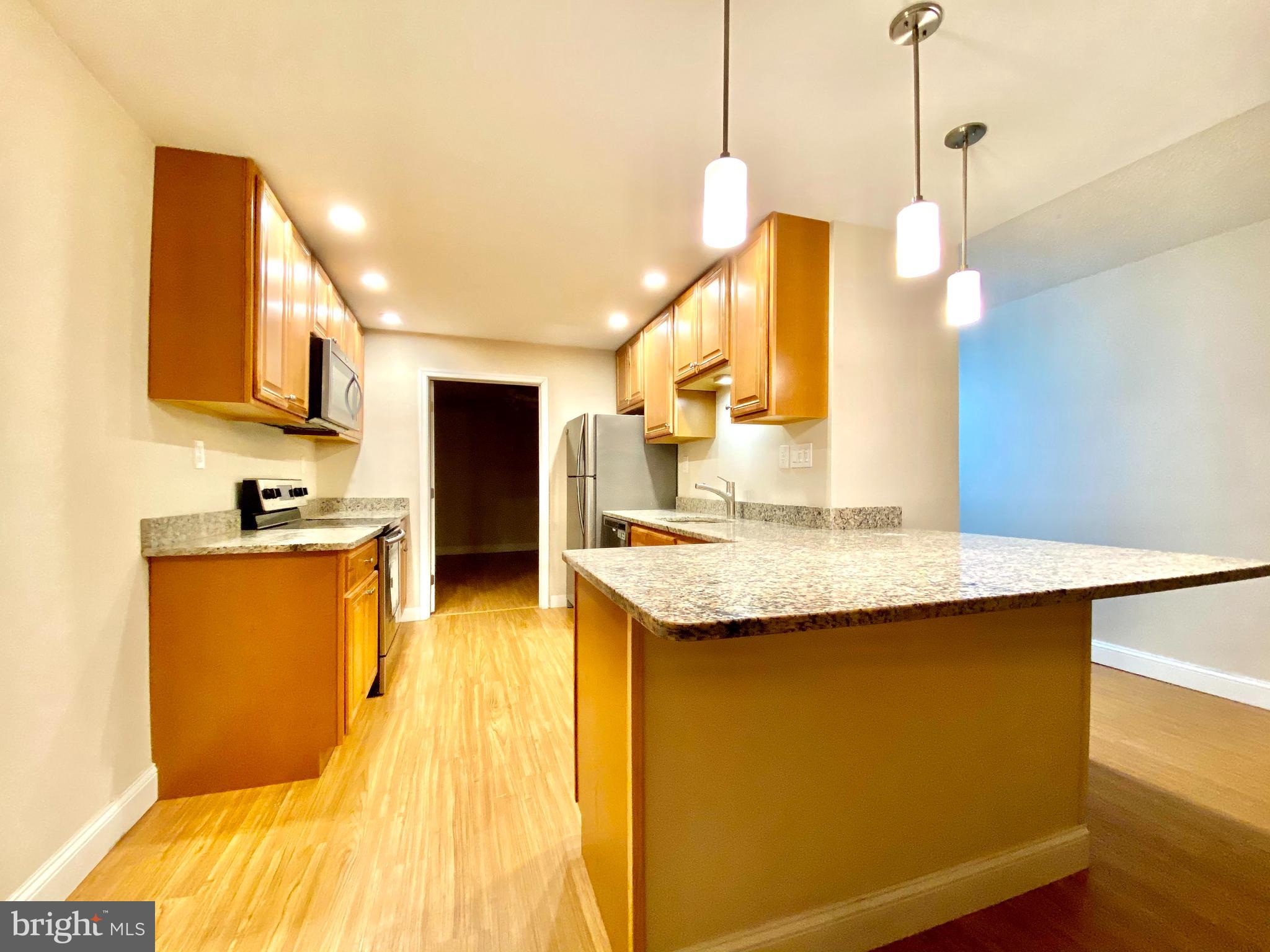 400 Glendale Road Havertown, PA 19083 - Photo 4 of 24 a kitchen with stainless steel appliances granite countertop a sink a stove and a wooden floors