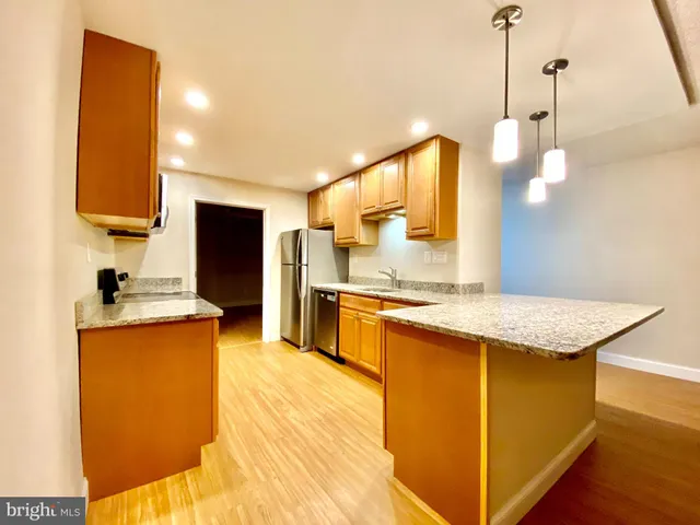 a kitchen with stainless steel appliances granite countertop wooden cabinets a oven and a sink