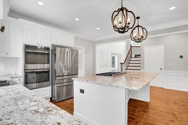 a kitchen with stainless steel appliances granite countertop a sink a stove and a refrigerator