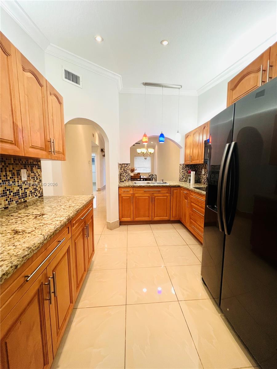 3380 Northeast 9th Street, Unit 203 Homestead, FL 33033 - Photo 12 of 21 a kitchen with stainless steel appliances granite countertop a refrigerator and a stove top oven