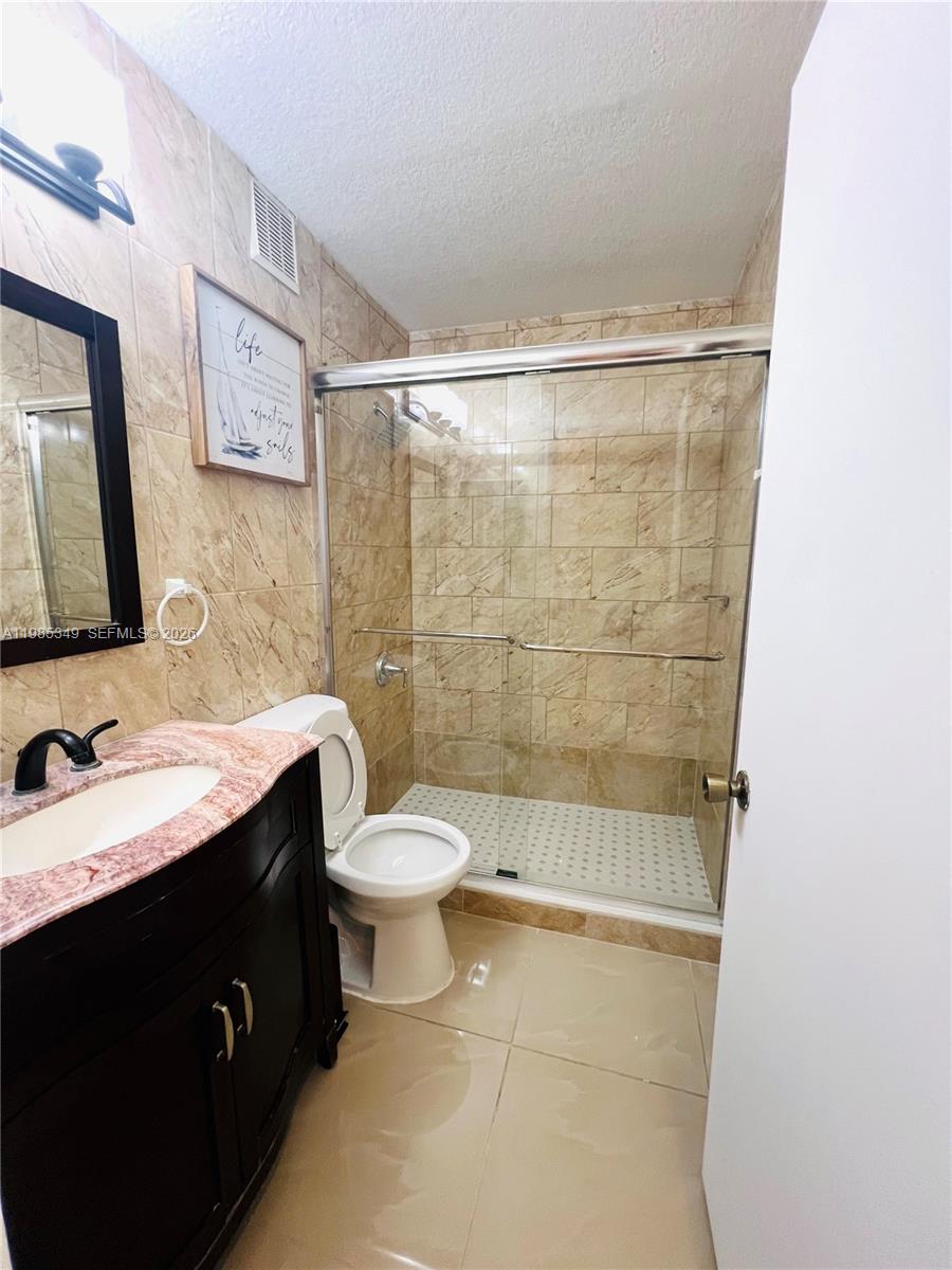 3380 Northeast 9th Street, Unit 203 Homestead, FL 33033 - Photo 17 of 21 a bathroom with a double vanity sink toilet and shower