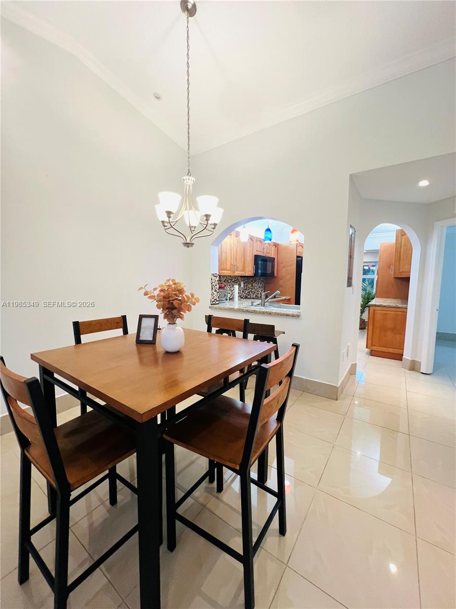 3380 Northeast 9th Street, Unit 203 Homestead, FL 33033 - Photo 19 of 21 a dining room table chairs and a chandelier