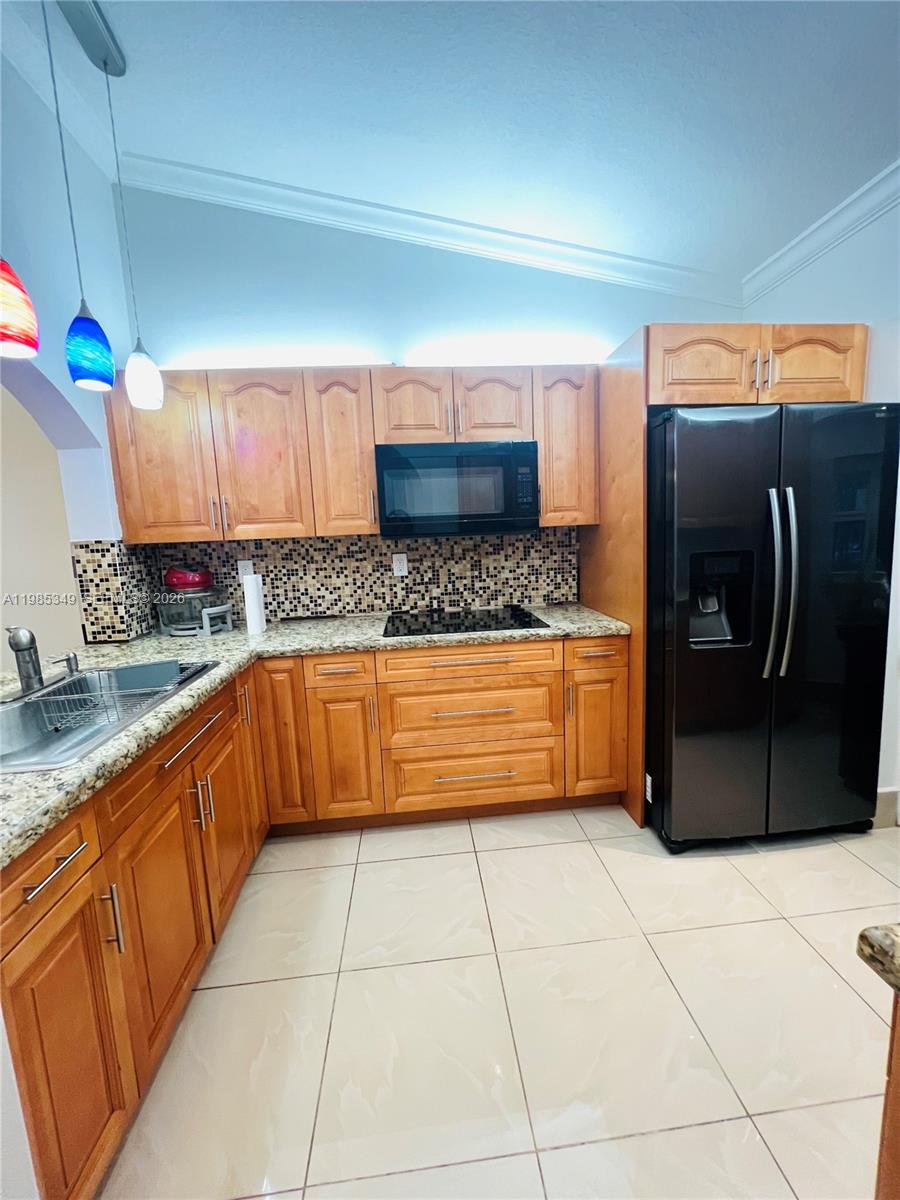 3380 Northeast 9th Street, Unit 203 Homestead, FL 33033 - Photo 20 of 21 a kitchen with stainless steel appliances granite countertop a sink a stove and a microwave