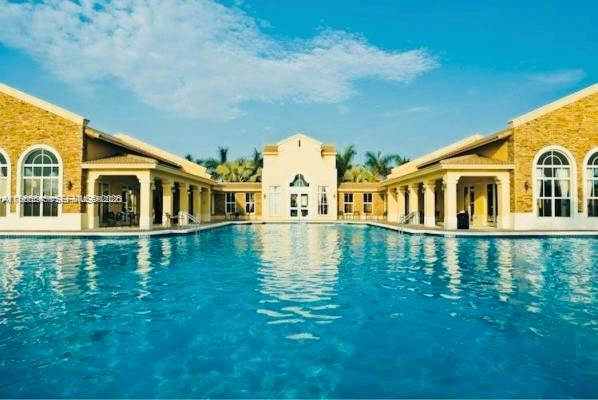 3380 Northeast 9th Street, Unit 203 Homestead, FL 33033 - Photo 2 of 21 a swimming pool with some trees in the background