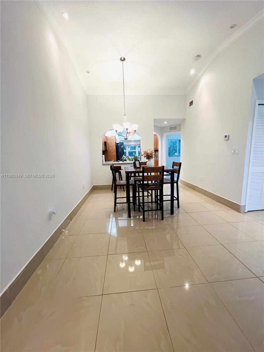 3380 Northeast 9th Street, Unit 203 Homestead, FL 33033 - Photo 7 of 21 a view of a dining room with furniture and chandelier